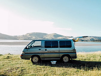 Silver Toyota Van Camping by Lake with Surfboard