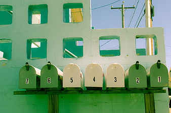 Green and White Mailboxes on a Colorful Wall