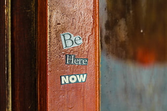 Be Here Now cutout letters on wet wooden door frame