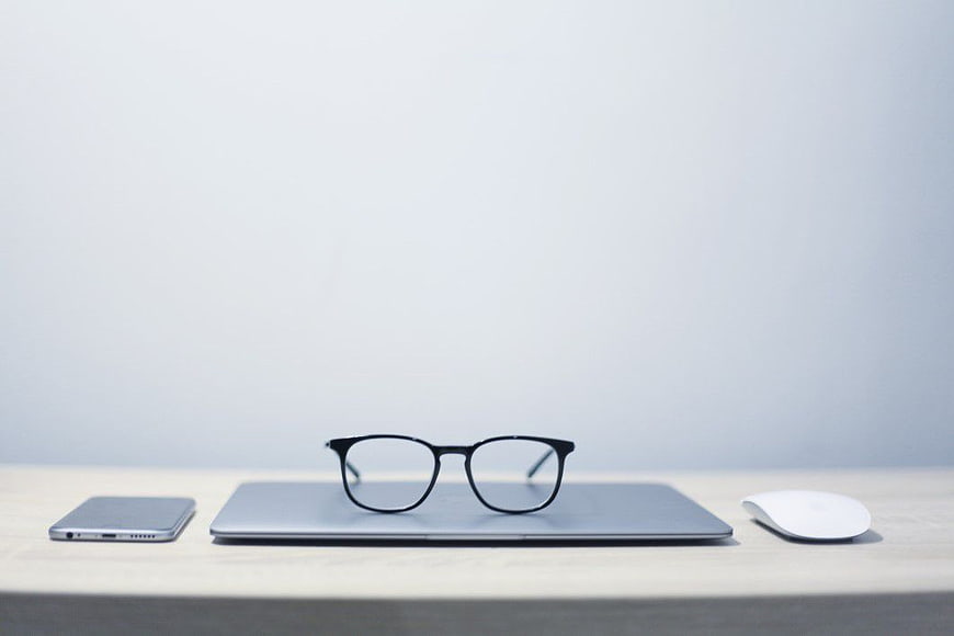 Minimalist Workspace with Laptop, Glasses, and Smartphone