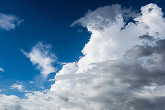 Dramatic White Cumulus Clouds Against Deep Blue Sky