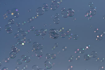 Abstract Soap Bubbles Floating Against Blue Background