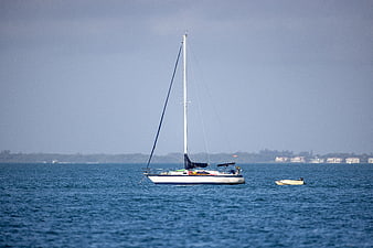 White Sailboat Anchored in Blue Ocean Water
