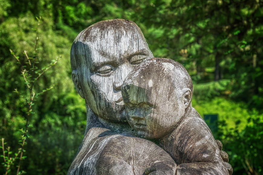 Wooden Sculpture of Mother and Child Embracing in Nature