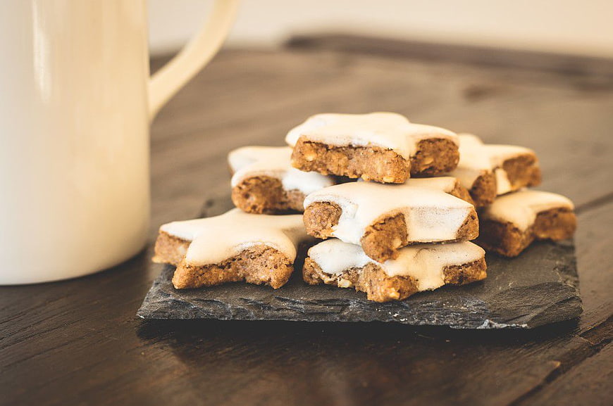 Star-shaped gingerbread cookies with white icing on slate