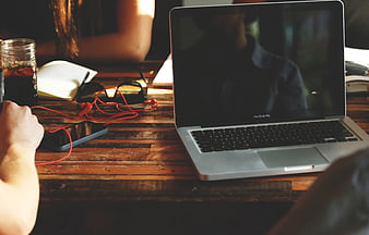 Laptop and smartphone on rustic wooden table with coffee