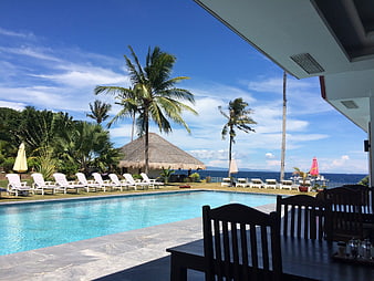 Tropical Resort Swimming Pool With Ocean View And Lounge Chairs