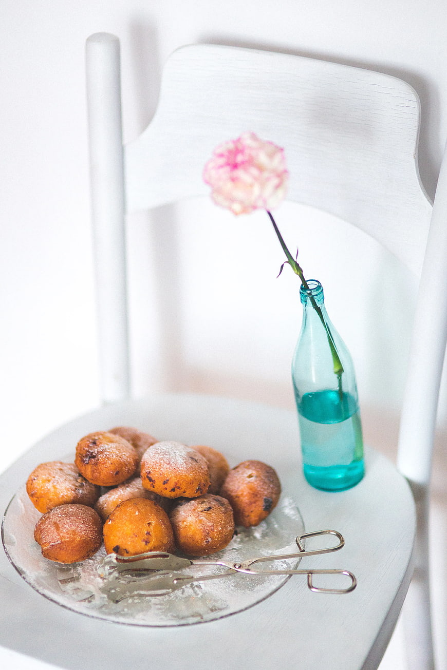 Homemade doughnuts on white chair with blue bottle