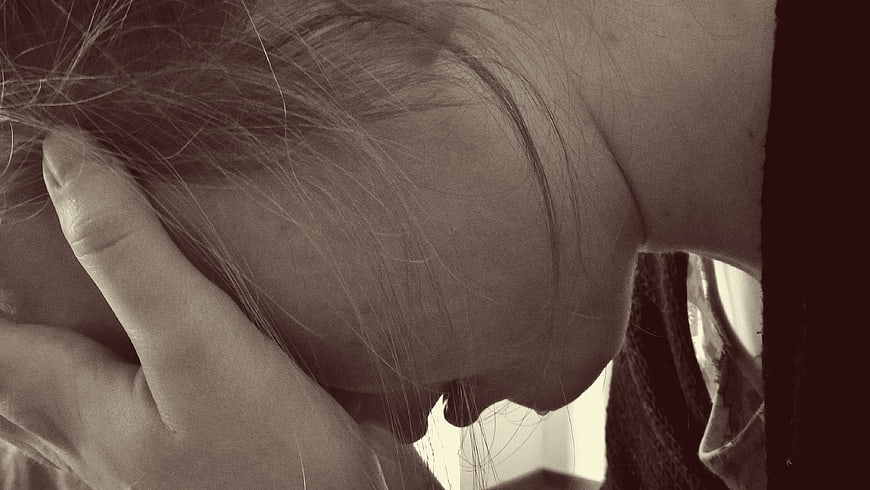 Close-up of woman holding head in despair and grief