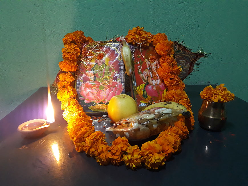 Laxmi Puja altar with marigold garlands and oil lamp