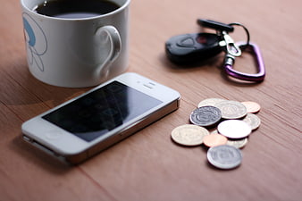 Smartphone, Coffee Mug, Keys, and Coins on Wooden Table