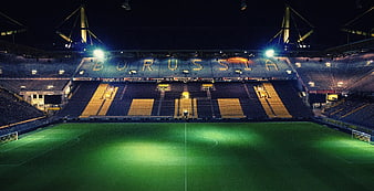 Empty Borussia Dortmund Stadium at Night with Floodlights