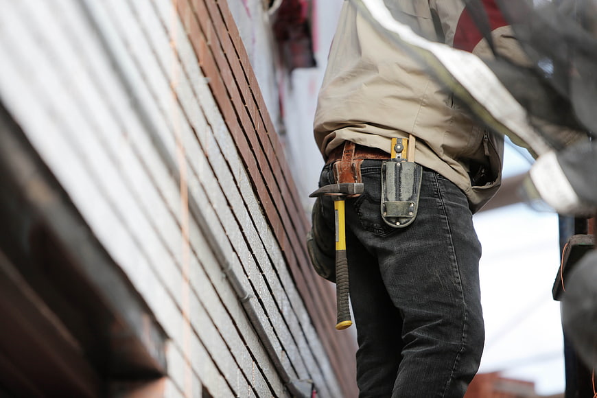 Construction Worker with Hammer and Tools on Belt