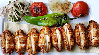 Grilled chicken wings with roasted vegetables and salad