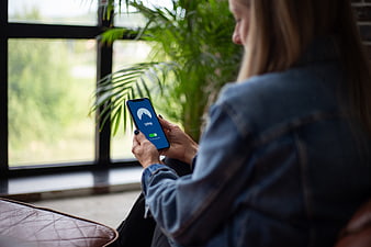 Woman using VPN app on smartphone by window