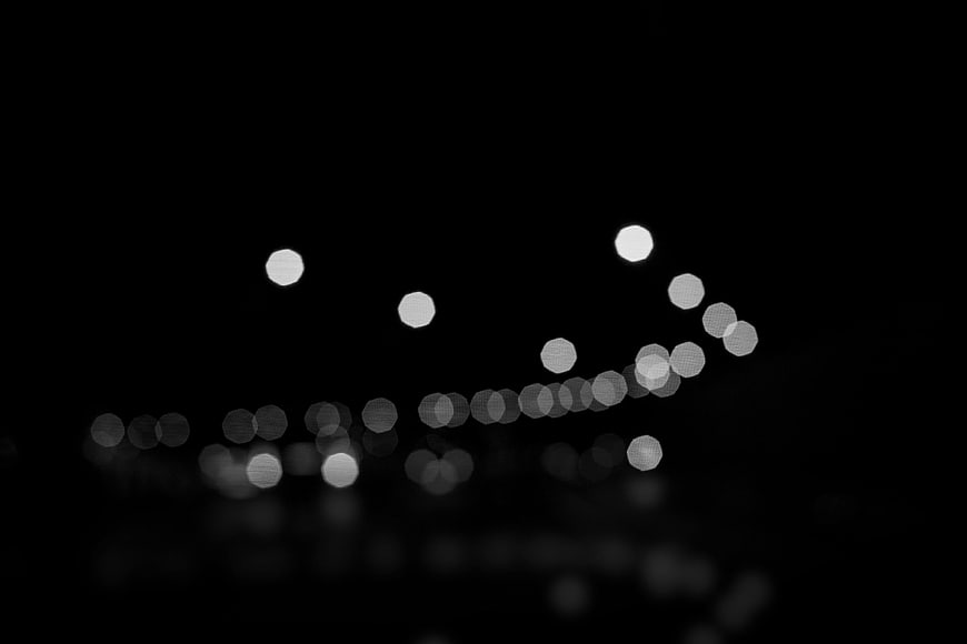 Abstract black and white bokeh lights on dark background