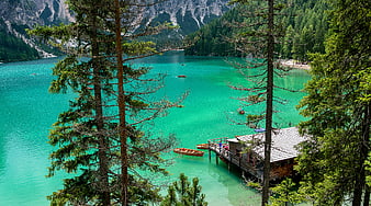 Turquoise alpine lake with wooden dock and pine trees