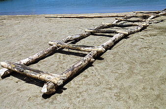 Rustic wooden boat rack on sandy beach