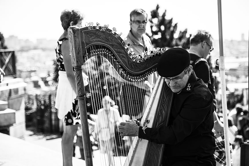 Senior Musician Playing Harp Outdoors in Black and White