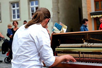 Man Playing Grand Piano Outdoors in Public Square