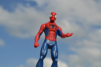 Spiderman Action Figure Toy Standing Against Blue Sky Background