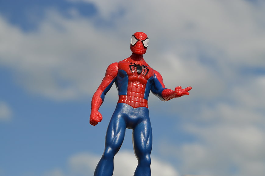 Spiderman Action Figure Toy Standing Against Blue Sky Background