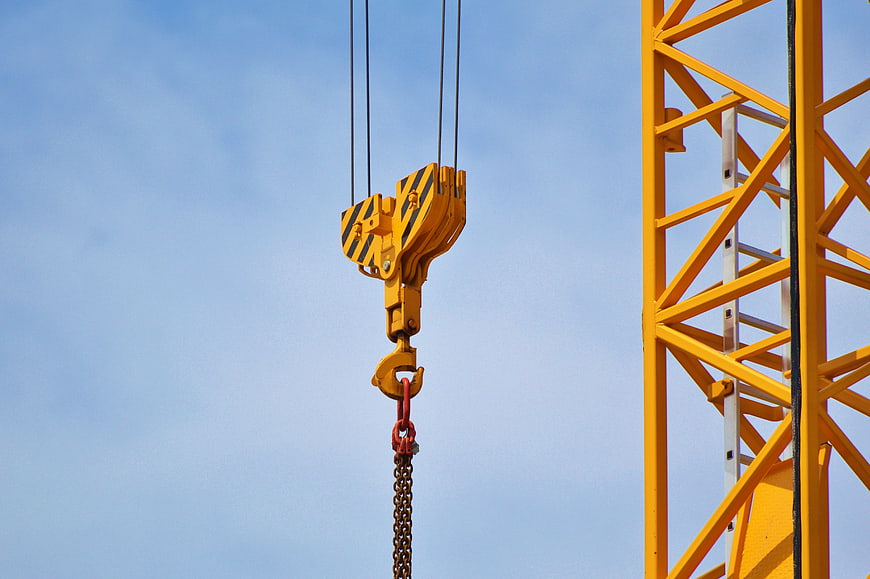 Yellow Construction Crane Hook Against Blue Sky