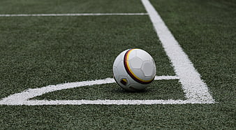 Soccer ball on corner of green artificial turf field