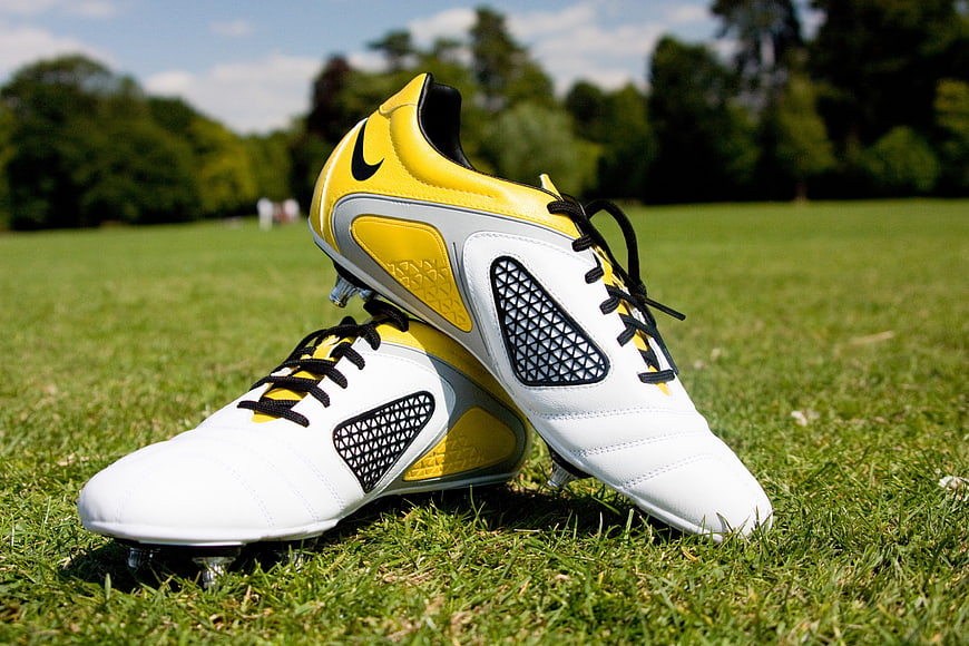 Yellow and white soccer cleats on green grass field