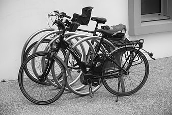 Black and white bicycle parked at metal rack