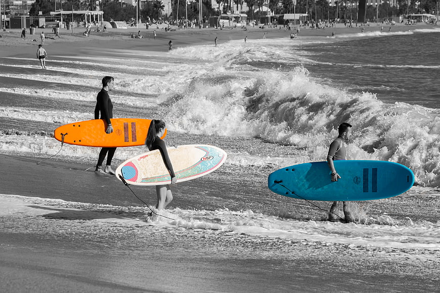 Surfers with Colorful Boards on Black and White Beach