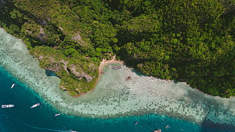 Aerial view of tropical island with turquoise water and boats