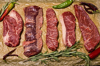 Raw Beef Steaks with Rosemary and Peppers on Brown Paper