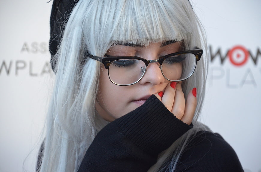 Close-up of woman with white wig and glasses in cosplay