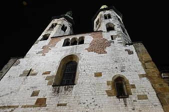 Low angle night view of historic church towers in Krakow