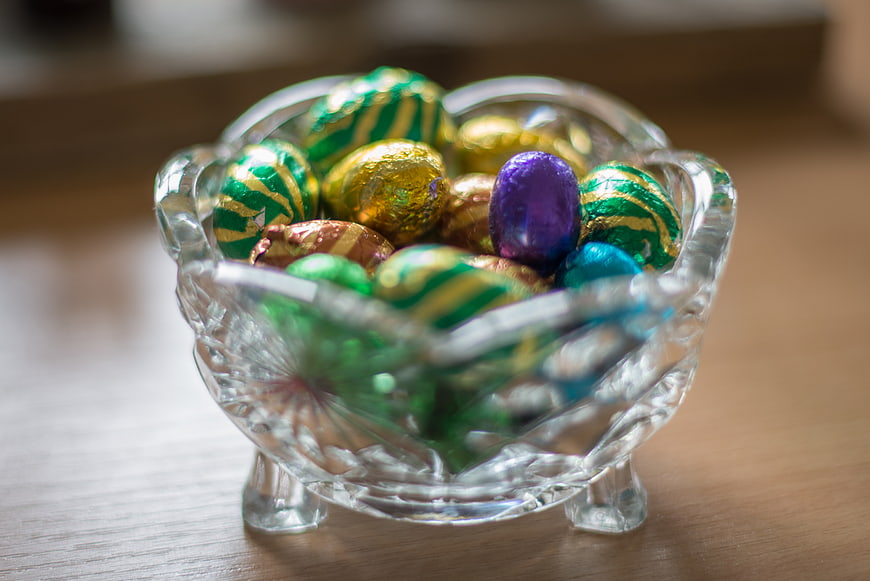 Colorful foil-wrapped chocolate eggs in a glass bowl