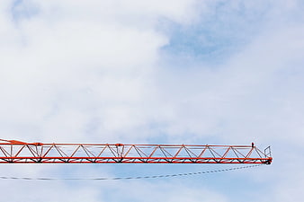 Red Construction Crane Boom Against Blue Sky