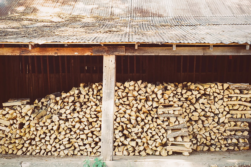 Stacked Firewood Under Rustic Barn Roof