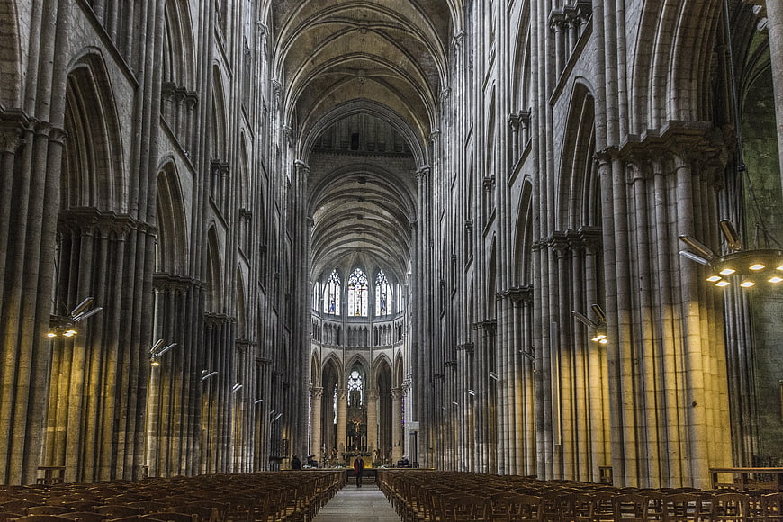 Man Walking Down Aisle of Gothic Cathedral Interior