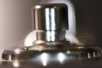 Macro close-up of chrome guitar footswitch pedal