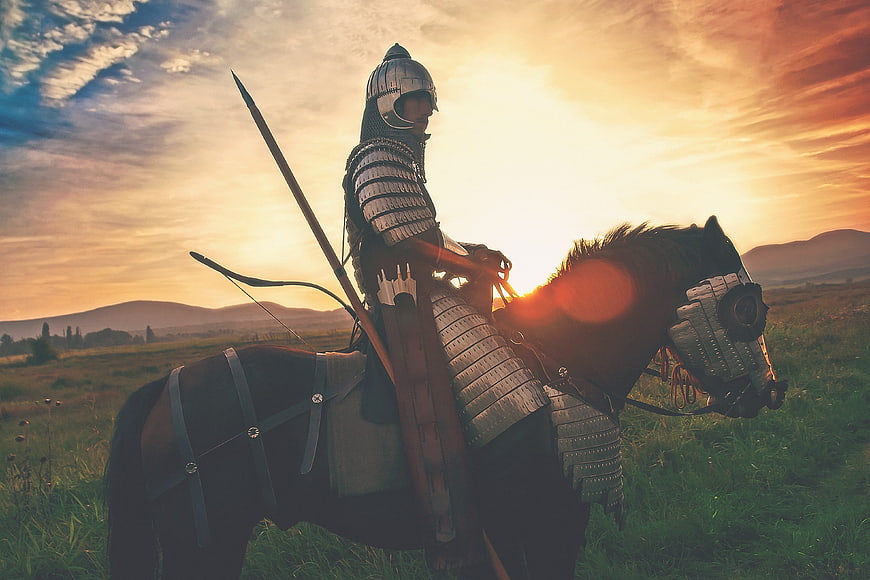 Medieval Knight on Horseback at Sunset in Field