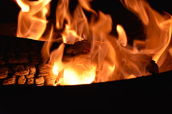 Close-up of burning wood logs in a dark fireplace