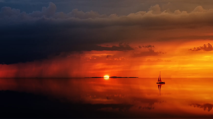 Silhouette of Sailboat on Calm Sea at Dramatic Sunset