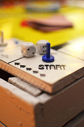 Close-up of board game start space with dice and pawn
