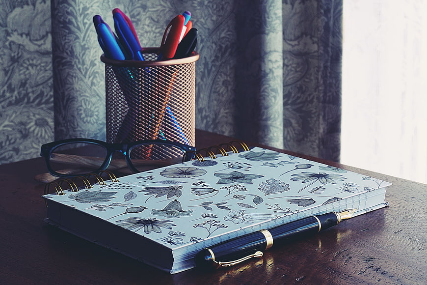 Vintage Notebook, Pen, and Glasses on Wooden Desk