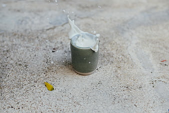 Milk Splash in Green Cup on Sandy Beach