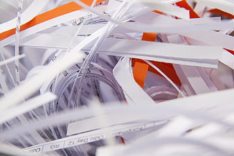 Close-up of shredded paper strips with orange accents