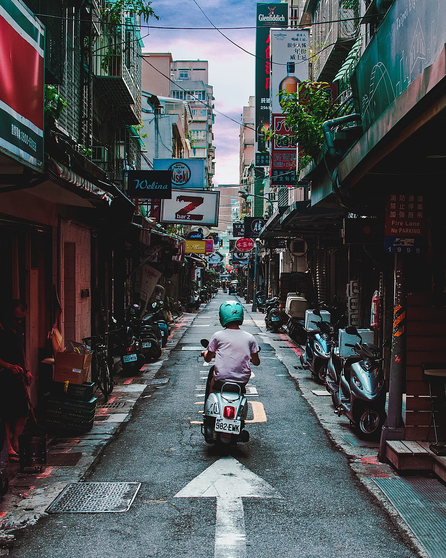 Scooter Rider in Taipei Alley with Neon Signs and Parked Bikes