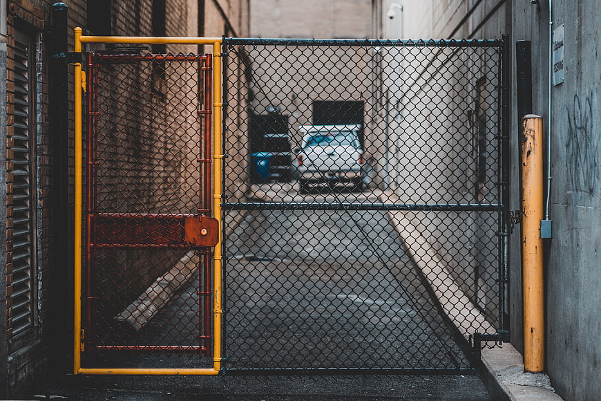 Yellow and Red Chain Link Gate in Urban Alley