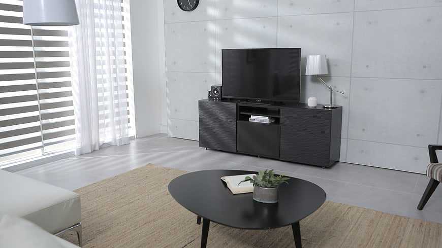 Modern minimalist living room with concrete walls and black furniture